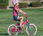 Το κορίτσι το ποδήλατο στο πάρκο, την άνοιξη του